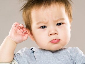 bébé étonné qui se touche l'oreille bébé étonné qui se touche l'oreille