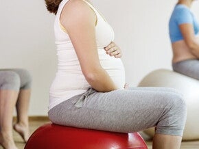 Cours de préparation à l'accouchement : femme enceinte sur ballon de grossesse Cours de préparation à l'accouchement : femme enceinte sur ballon de grossesse