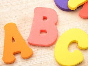 jeu de lettres colorés en mousse posé sur un parquet jeu de lettres colorés en mousse posé sur un parquet